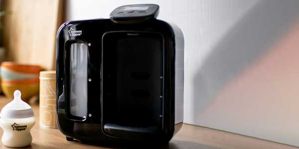 A Tommee Tippee perfect prep day & night machine in black colour placed with a bottle next to it.